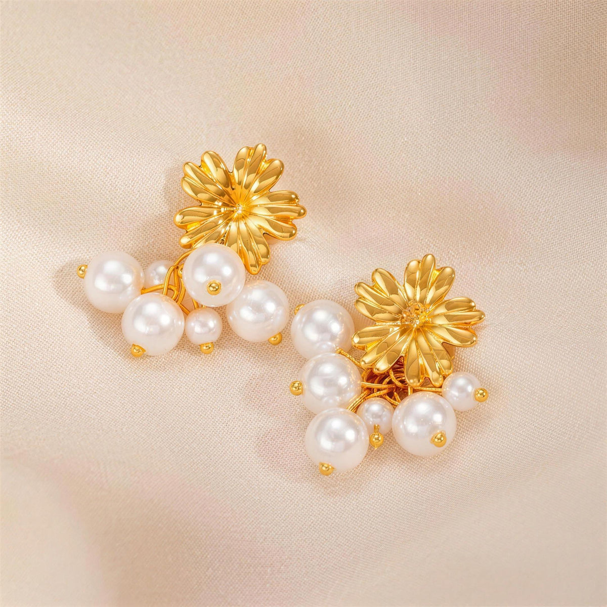 Gold floral pearl cluster earrings on satin
