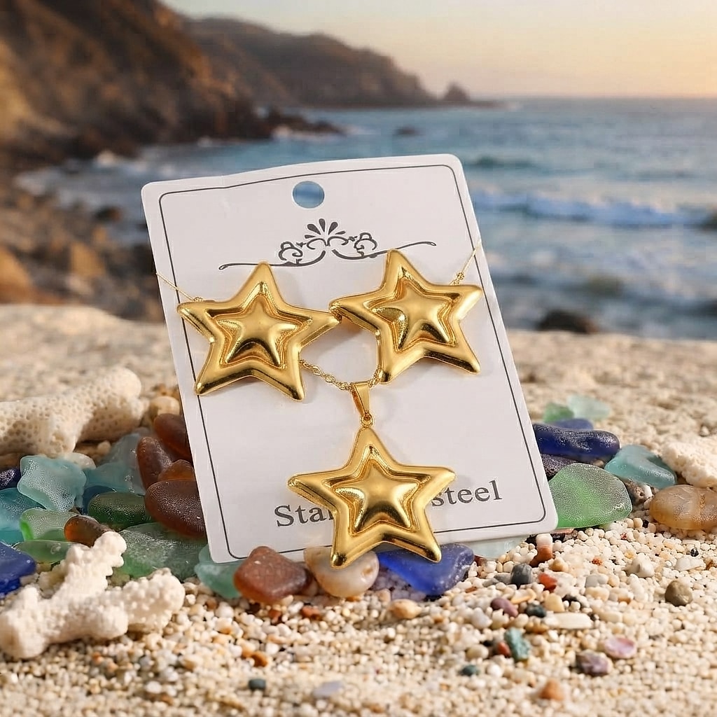 Gold star earrings and necklace set on a card by the sea