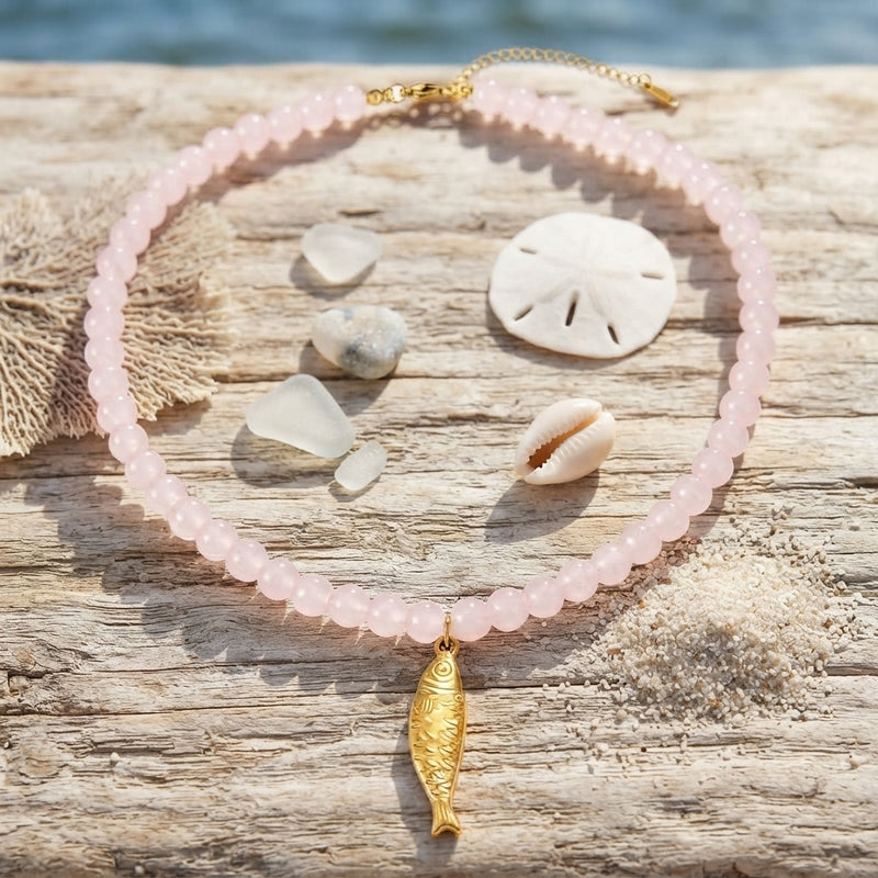 Light pink beaded necklace with a gold fish charm