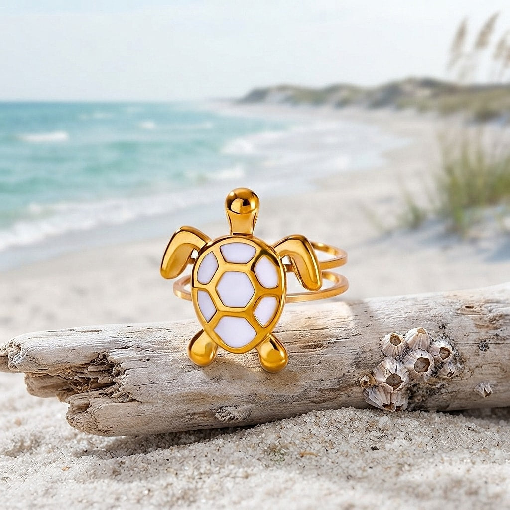 Gold turtle ring with white enamel shell on driftwood