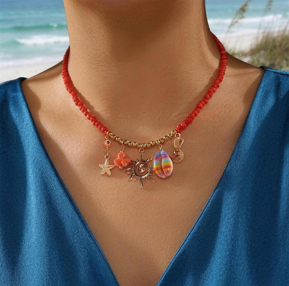 Orange beaded sun charm choker worn with a blue satin top