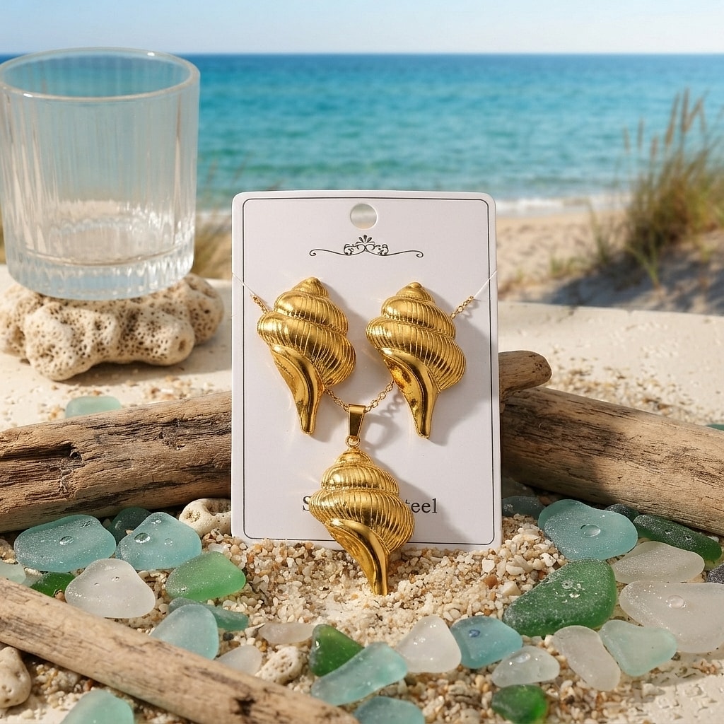 Gold seashell earrings and necklace set on a card by the sea
